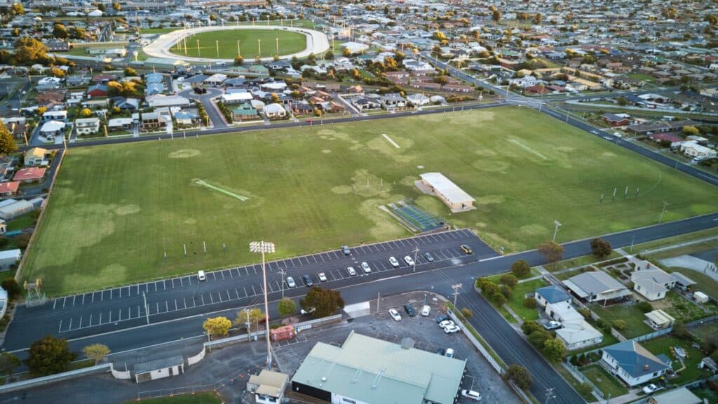 Aerial view of Australian suburban football field and parking.