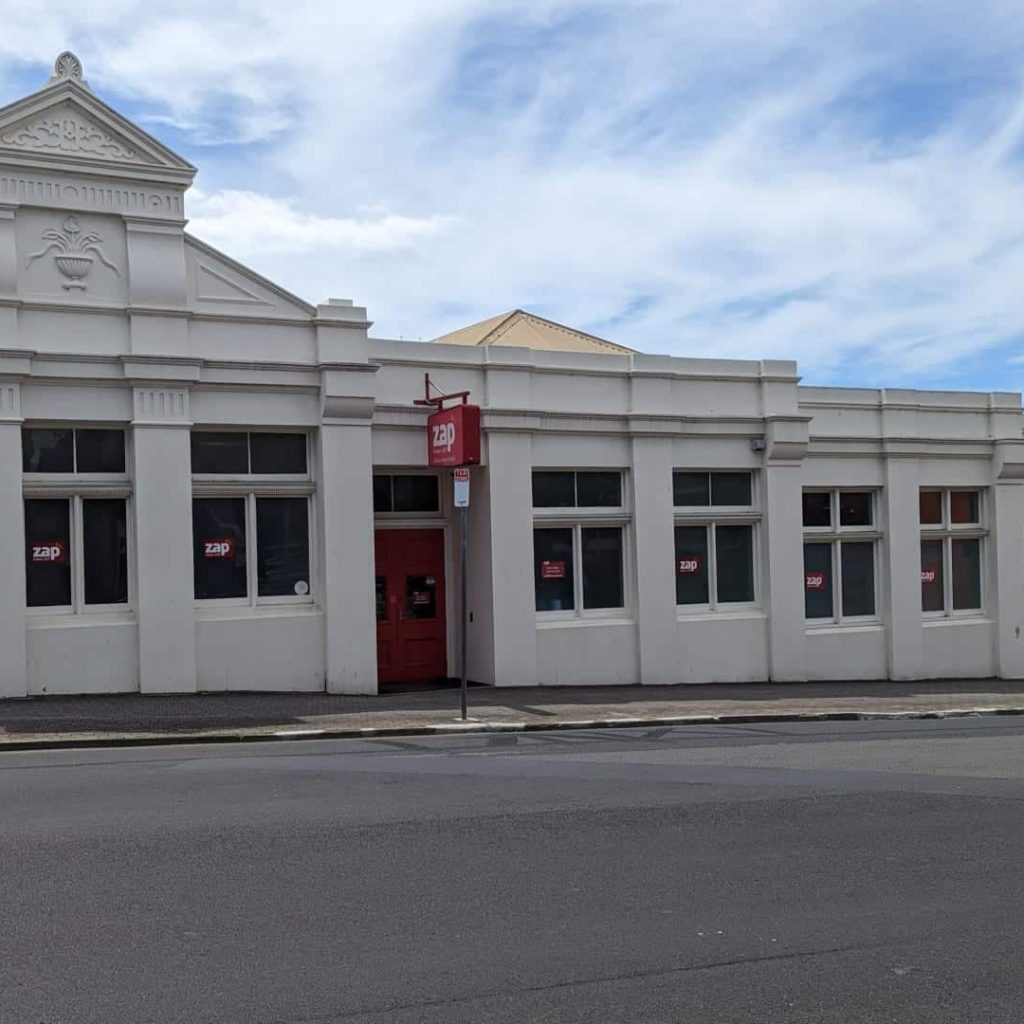 Historic Australian building with red door and signage.