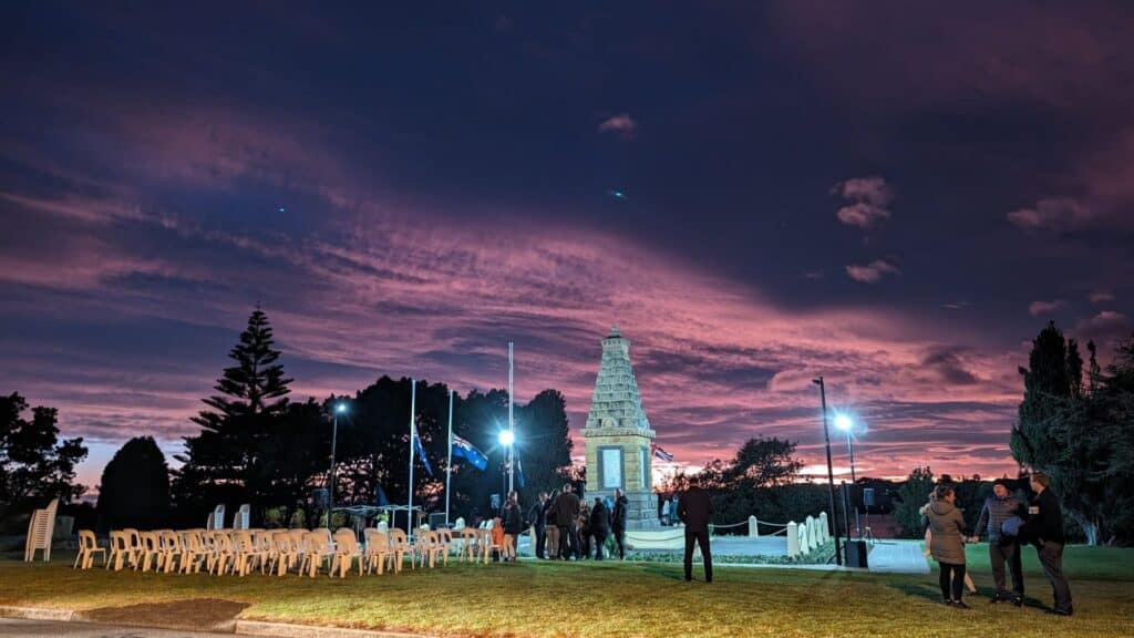 Sunset at Australian war memorial with people.